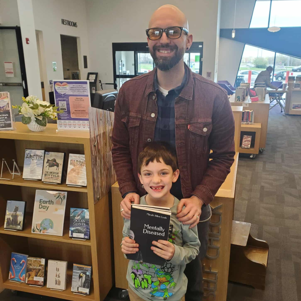 Micah Allen Losh with his son and published book
